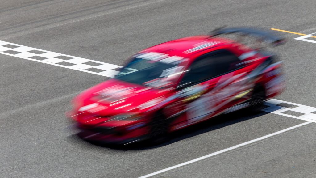 Motion blur race car racing on speed track, Car race on the international circuit race track.