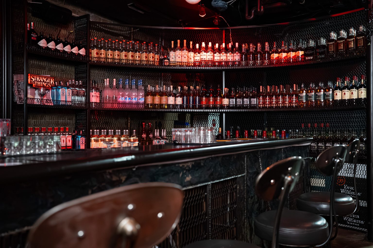 The Lair Chicago red-lit backbar and industrial stools