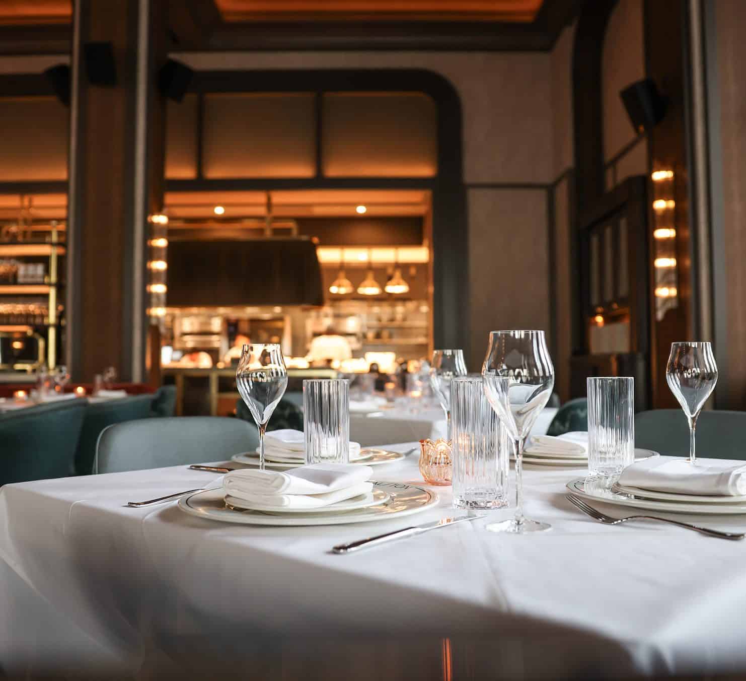 Alston Harvest Dinner table setting at The Alston Chicago with branded plate and open kitchen