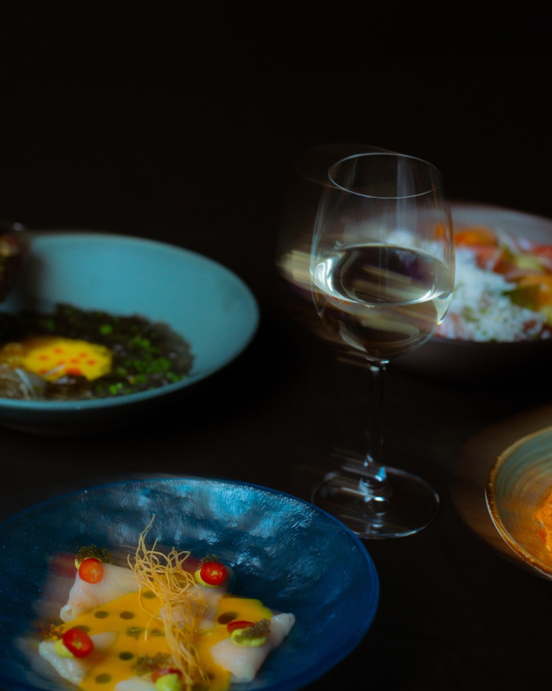 AMARA Chicago crudo and mezze plates with a glass of white wine
