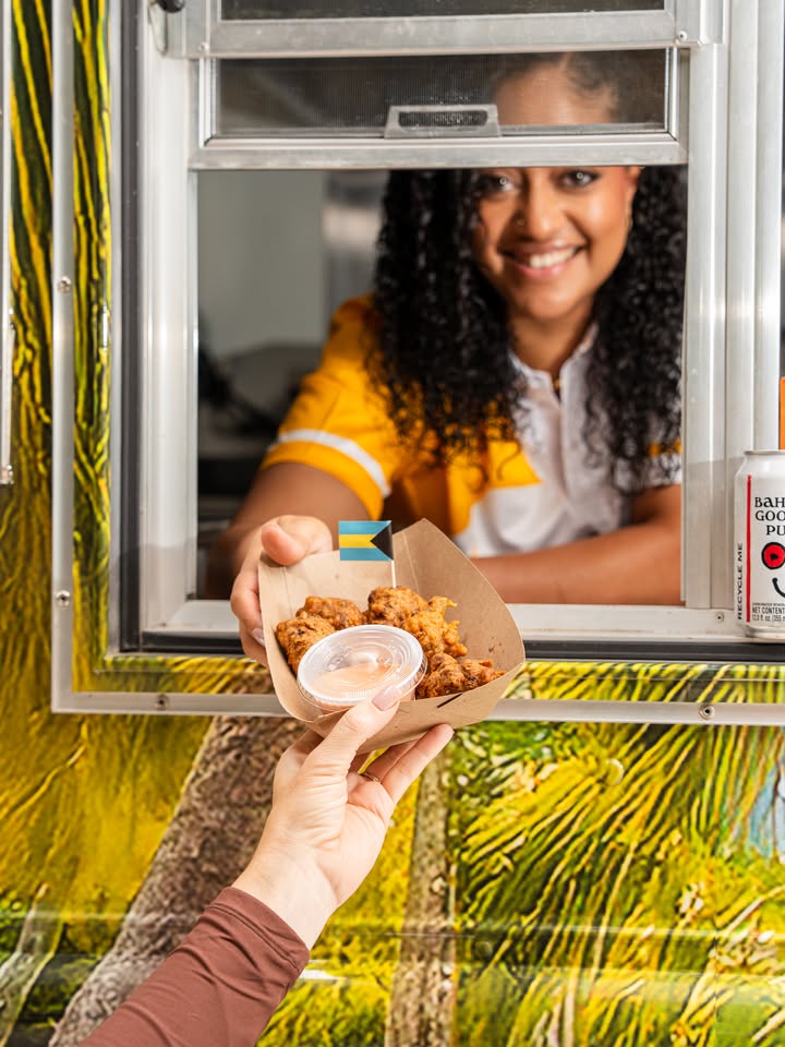 Chef Courtney Neil at Bahama Shack Chicago truck window handing conch fritters