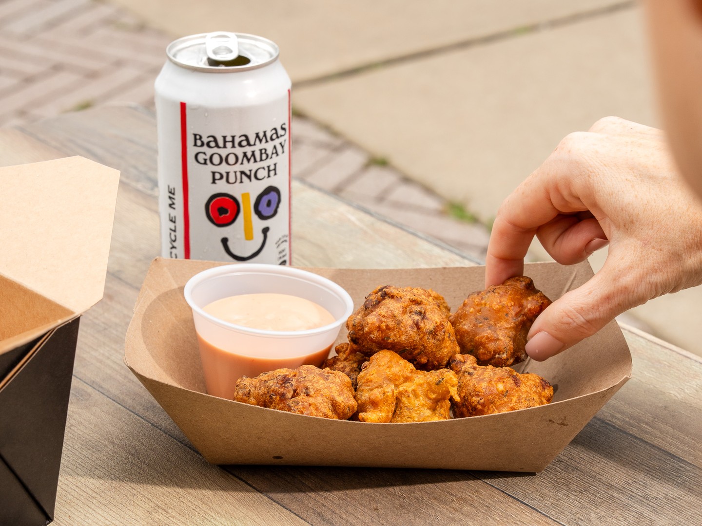 Bahama Shack Chicago conch fritters with dipping sauce and Goombay Punch can
