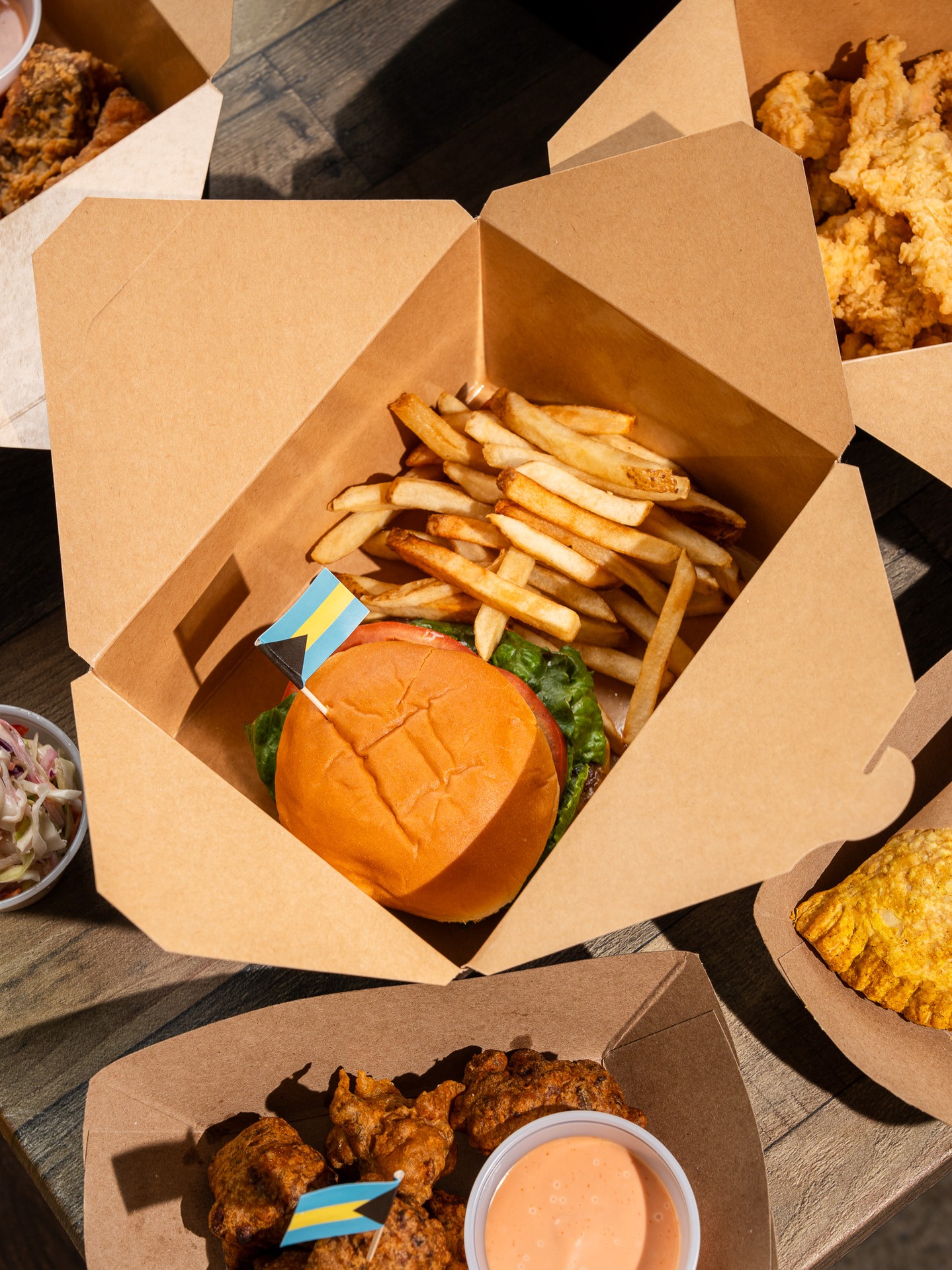 Bahama Shack Chicago smash burger with fries, conch fritters, and Bahamian flag toothpicks