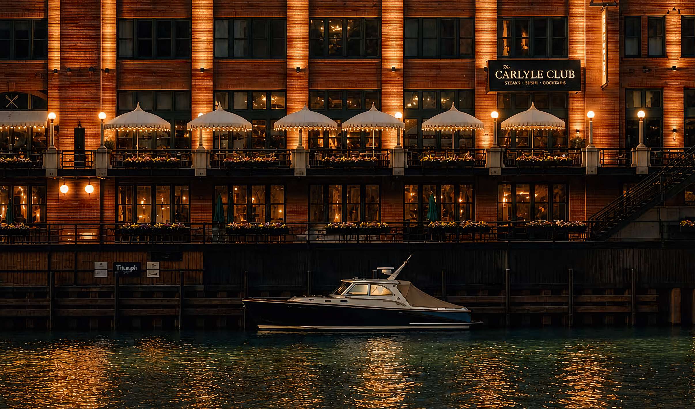 Carlyle Club Chicago riverfront patio and Reid Murdoch Building at night on the Chicago River