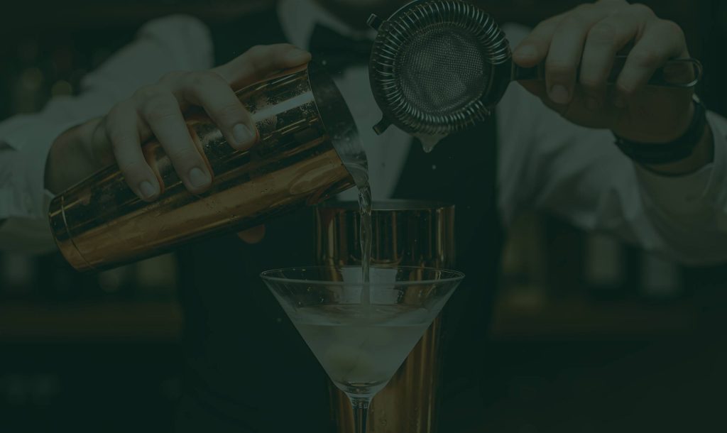Gibsons Tavern Chicago bartender pouring a martini from a copper shaker into a coupe glass