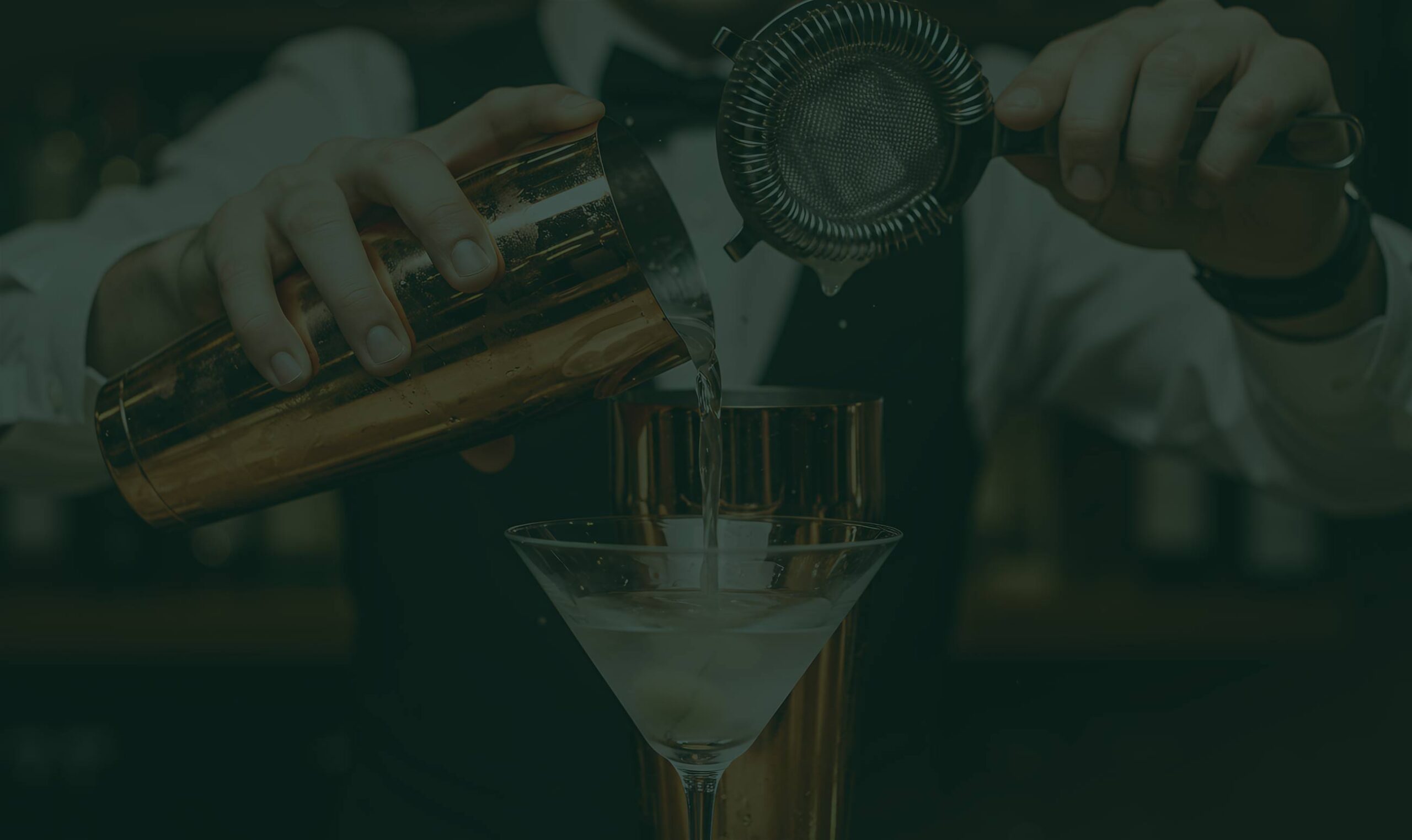 Gibsons Tavern Chicago bartender pouring a martini from a copper shaker into a coupe glass