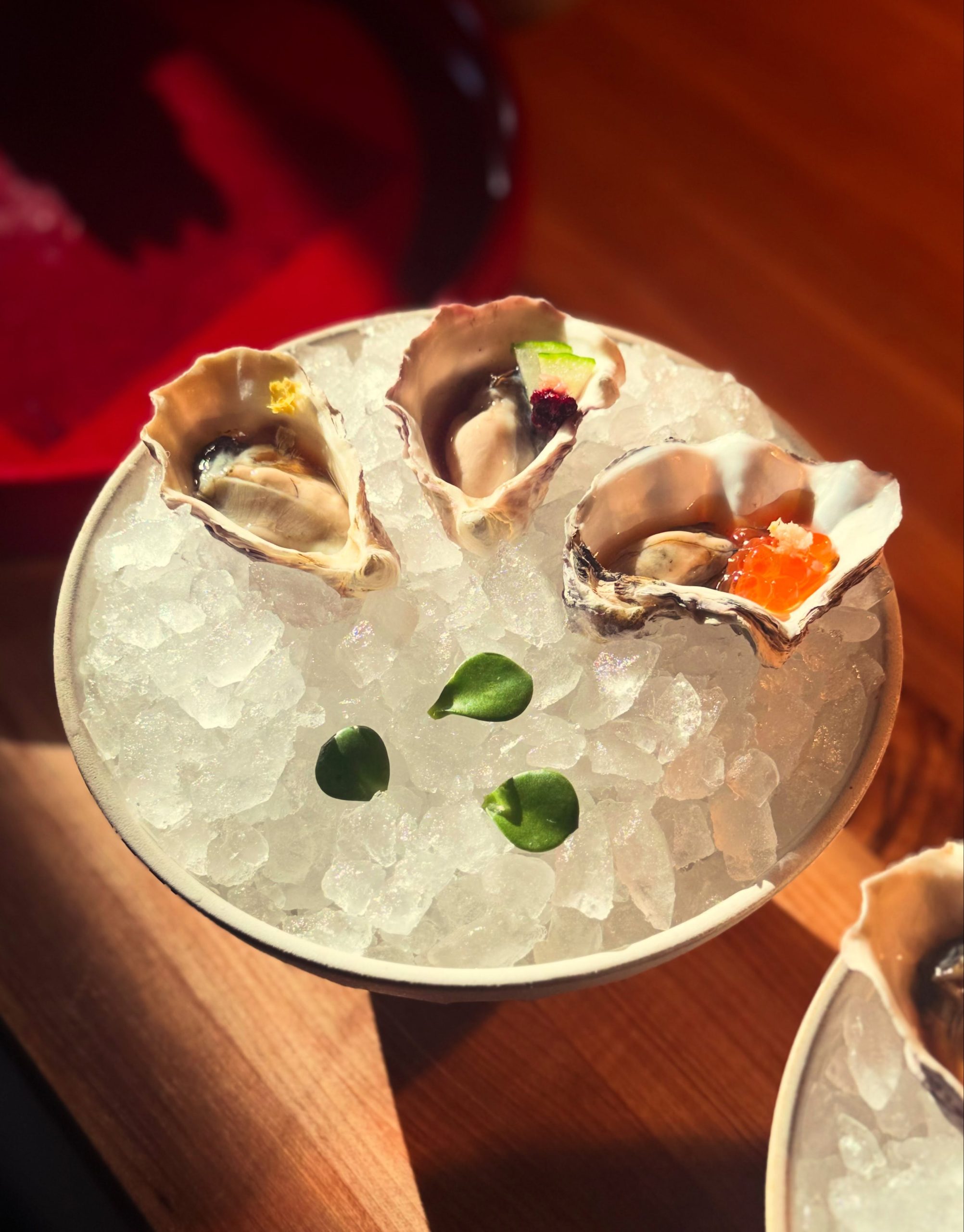 Kumiko Chicago oysters with seasonal ponzu-style toppings on the half shell