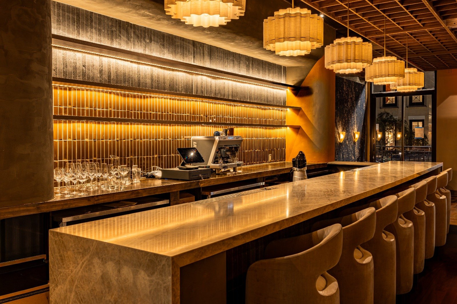 Osteria Gilberto Chicago bar with stone counter, gold backsplash, and warm pendant lights