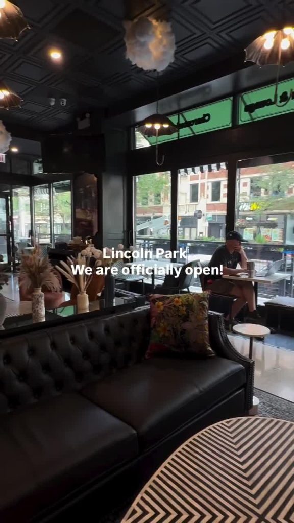 Piccadilly Market Lincoln Park lounge with tufted leather sofa and storefront windows at Clark and Fullerton