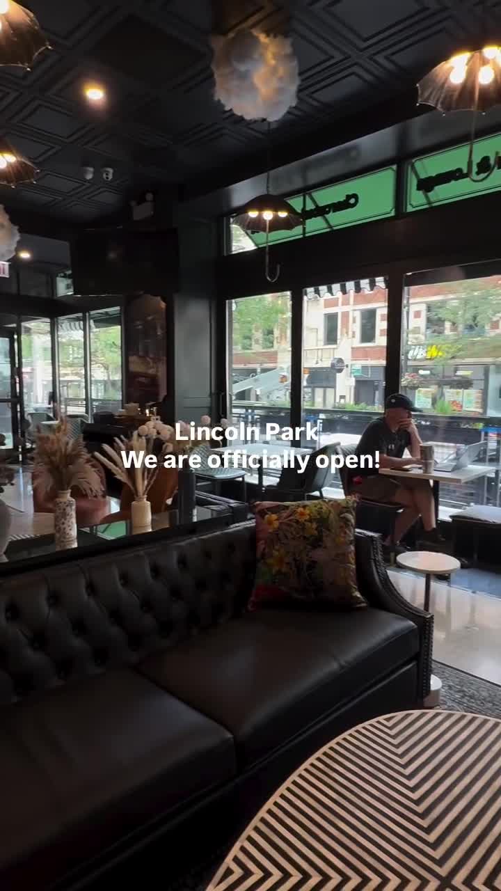 Piccadilly Market Lincoln Park lounge with tufted leather sofa and storefront windows at Clark and Fullerton