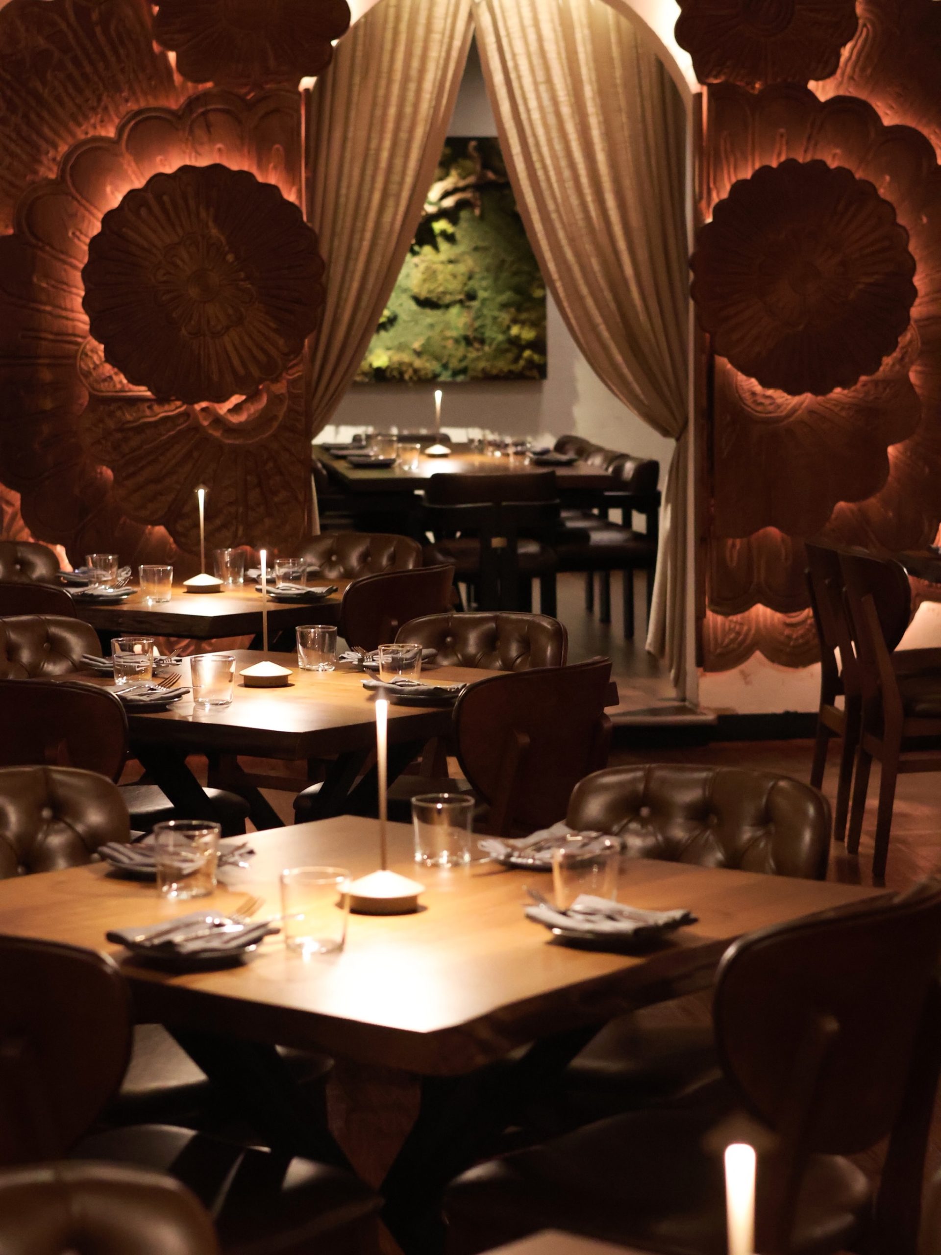 Susu Chicago West Loop dining room with carved wood archway and set tables