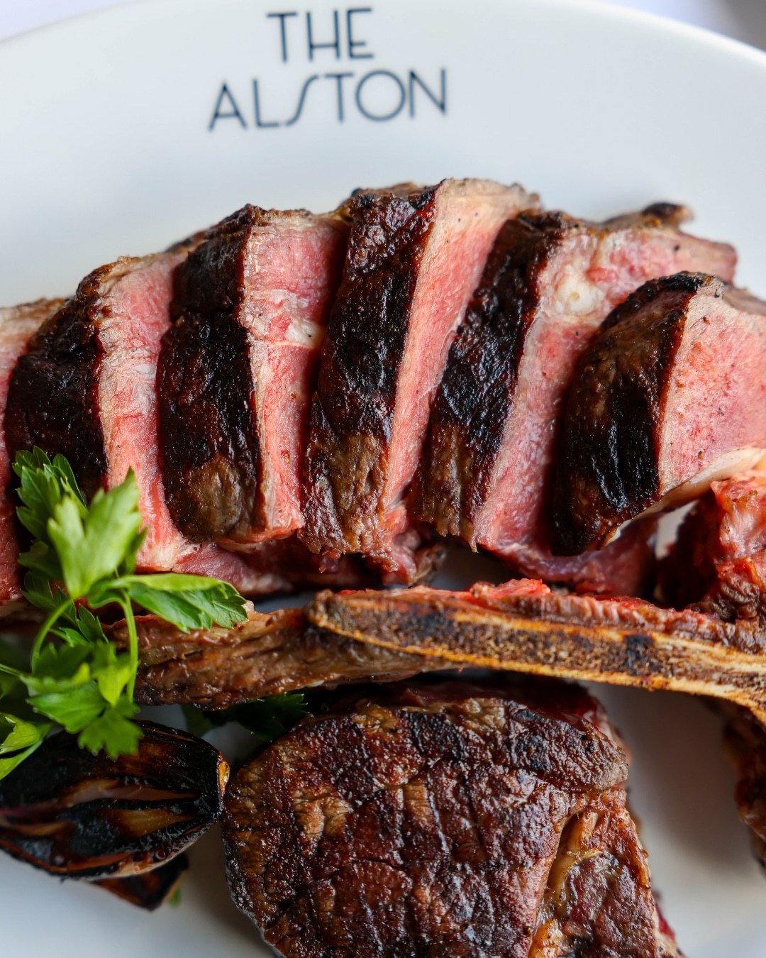 Bone-in sliced steak with roasted garlic at The Alston Chicago