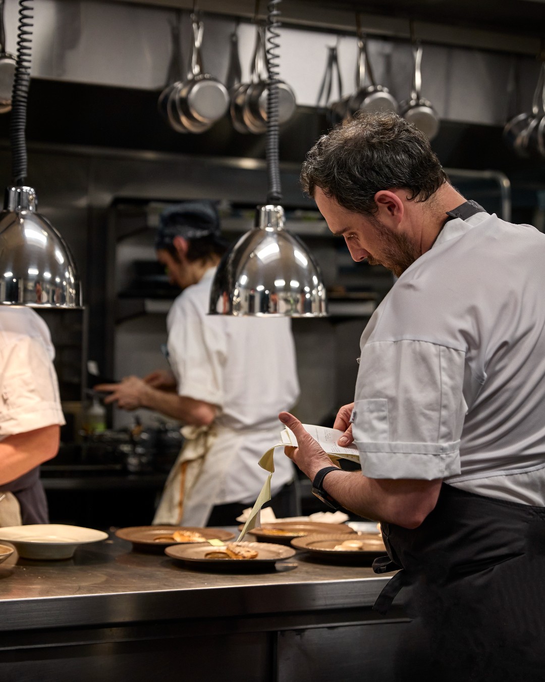 Cooks plate dishes at the pass in the kitchen at Boka in Chicago
