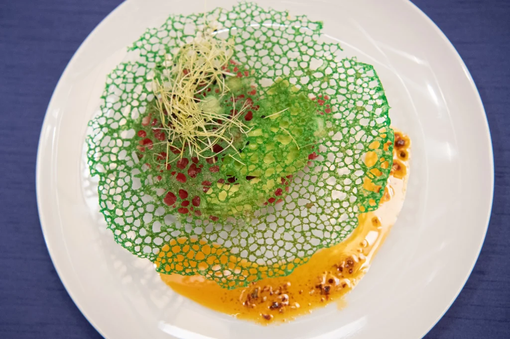 Tuna poke under a lacy green tuile with a saffron orange sauce, a tasting course at Celebrity Chef Ball Chicago