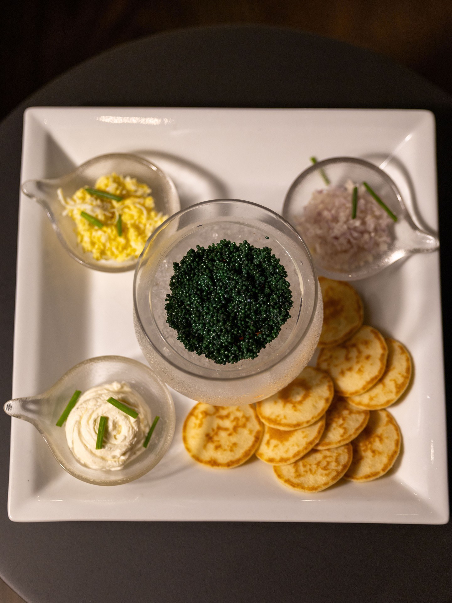 Caviar service with garnishes and potato chips at The Champagne Room