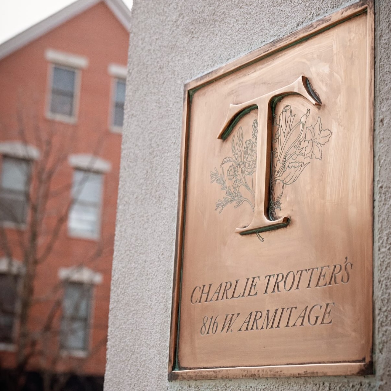 The brass Charlie Trotter's placard with its engraved T logo and the 816 Armitage address beside the brick facade