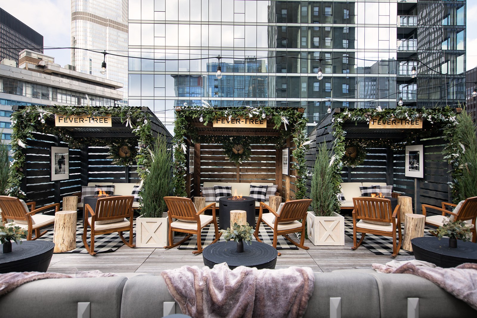 Private rooftop chalets with fireplaces, rocking chairs and holiday garland at Chateau Carbide above Michigan Avenue in Chicago