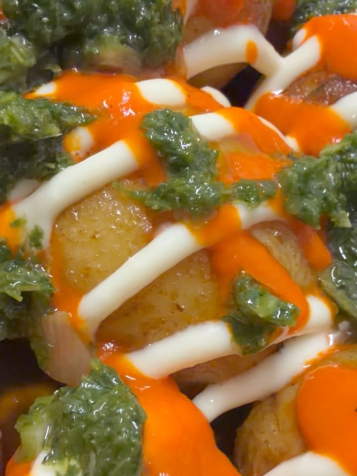 Rotisserie potatoes bravas topped with aioli, orange piquillo sauce and green chimichurri at Chez Poulet Chicago