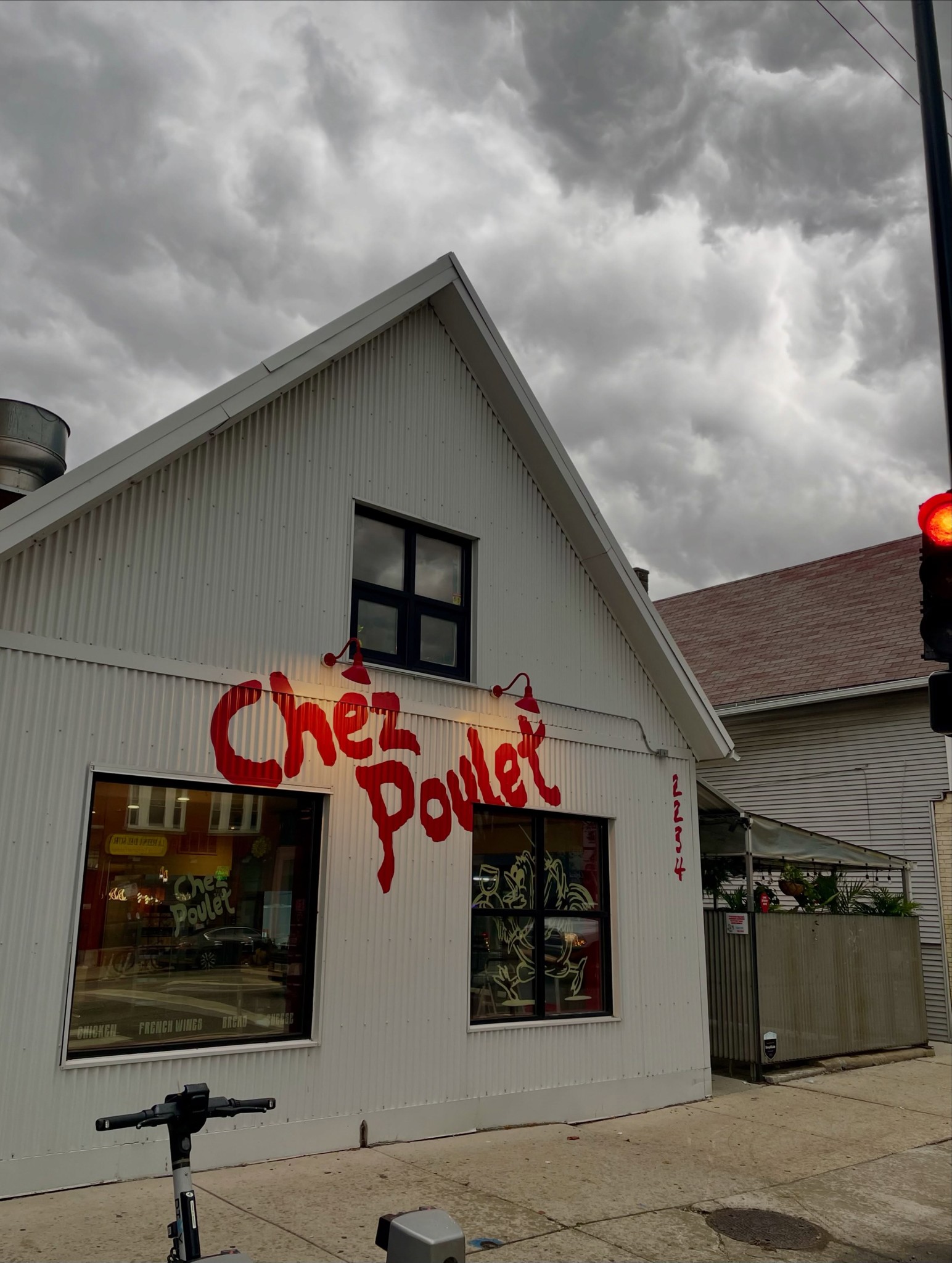 White clapboard building with a red Chez Poulet script sign at 2234 N. Western Ave. in Chicago