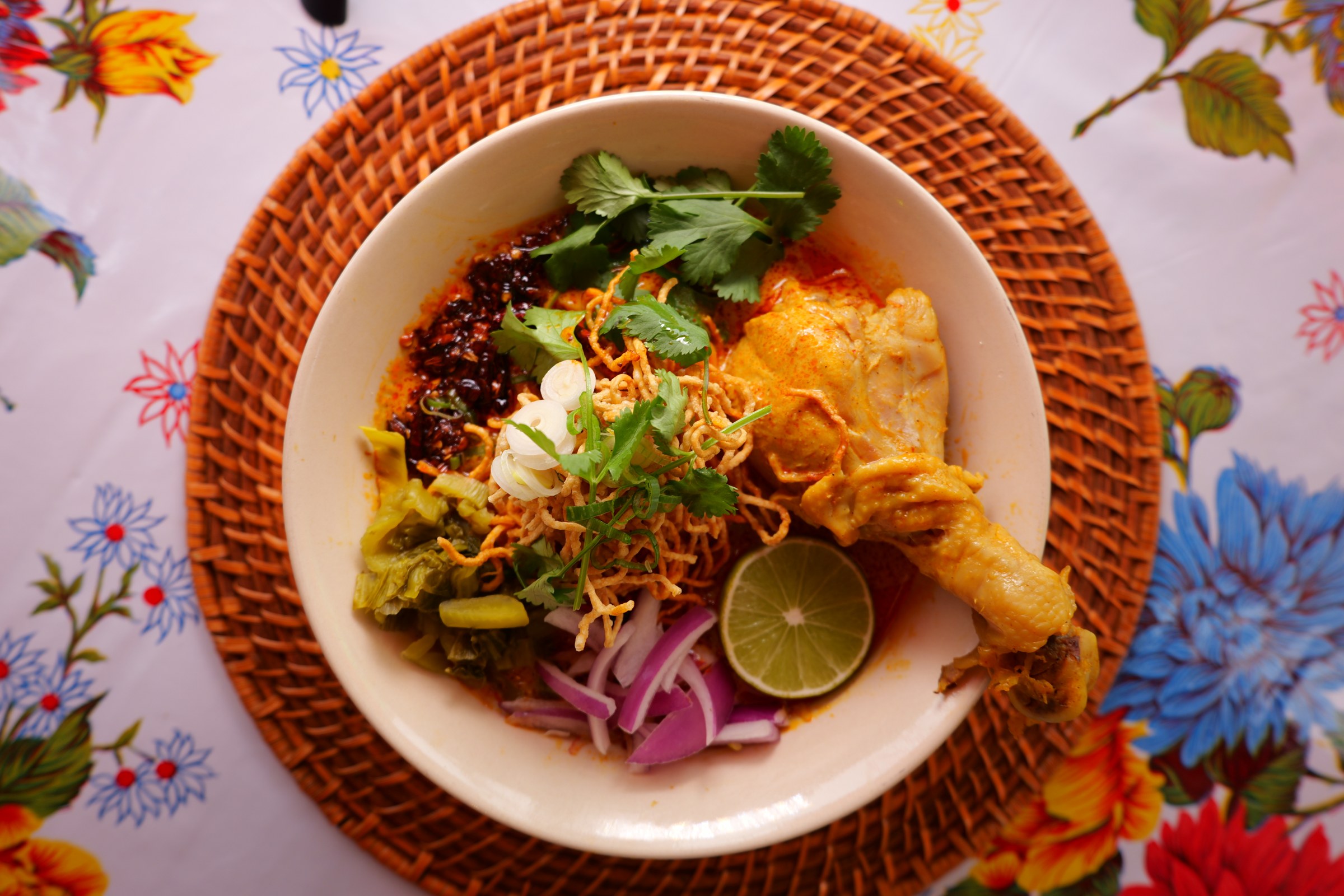 Chiang Mai Night Bazaar khao soi gai with chicken in coconut curry broth, crispy noodles, lime and pickled greens
