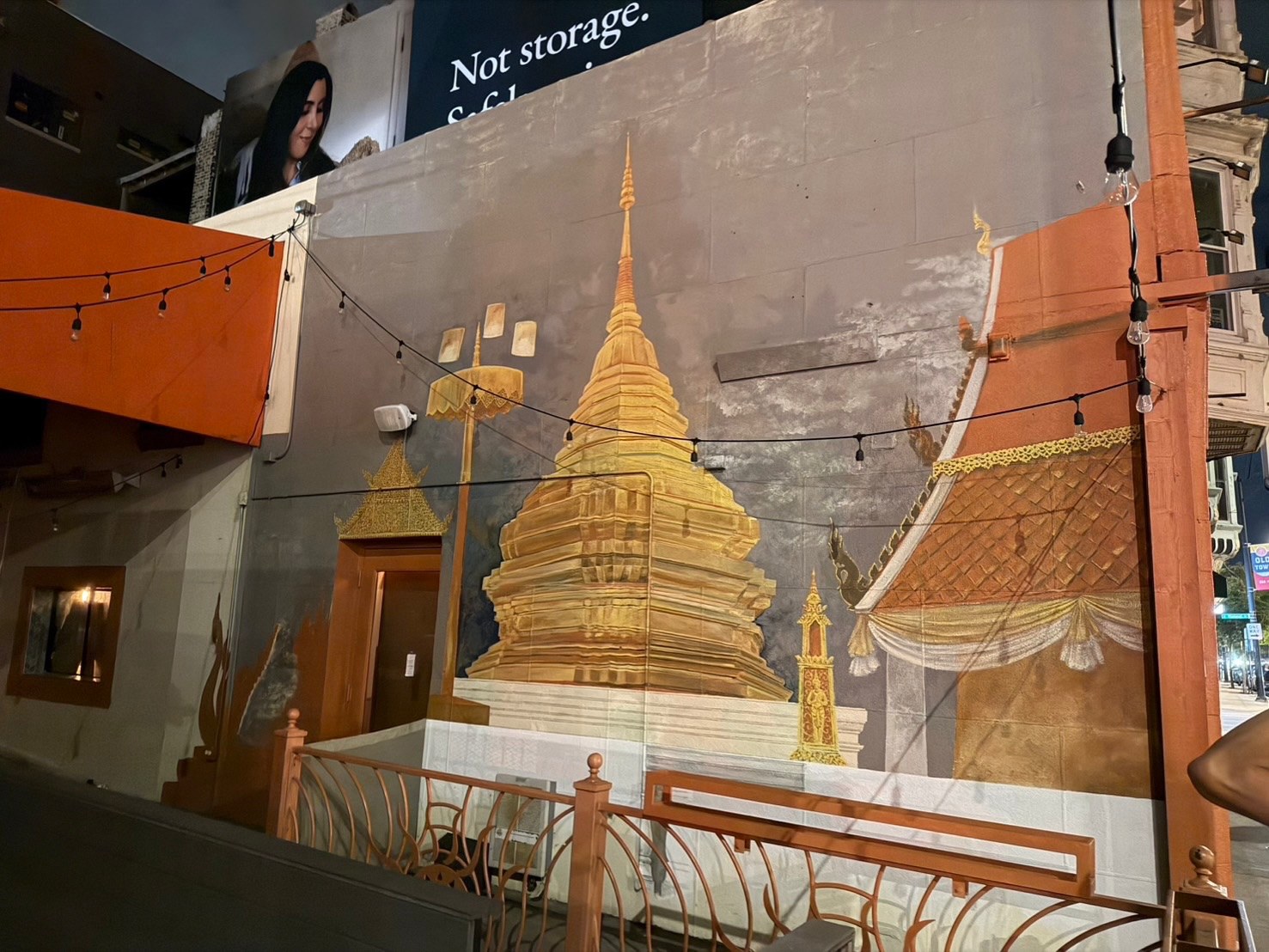 Chiang Mai Night Bazaar exterior mural of a golden temple spire with string lights on North Avenue in Old Town Chicago