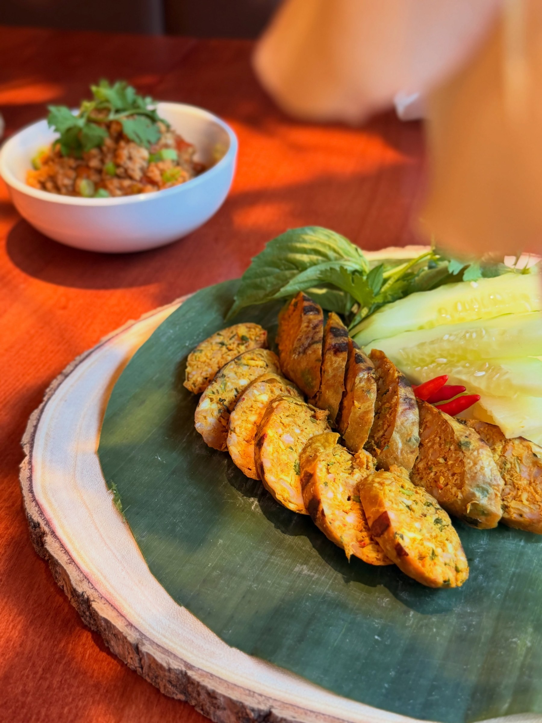 Chiang Mai Night Bazaar house-made sai oua Northern Thai herb sausage sliced on a banana leaf