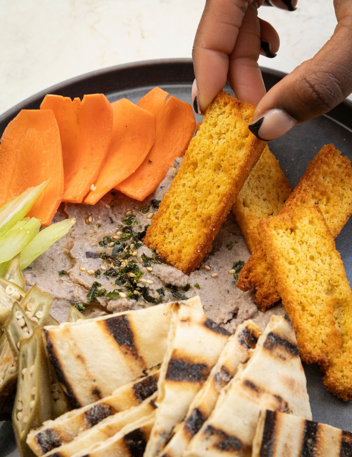 Black-eyed pea hummus with cornbread crostini, sliced roots and grilled naan