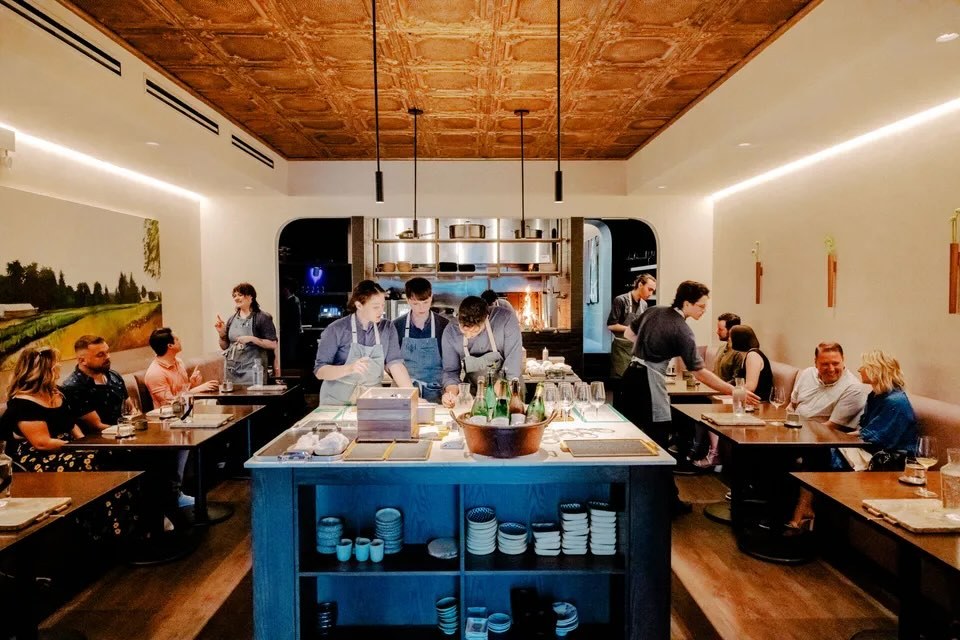 Feld Chicago dining room with the blue kitchen island in the center and guests seated around it