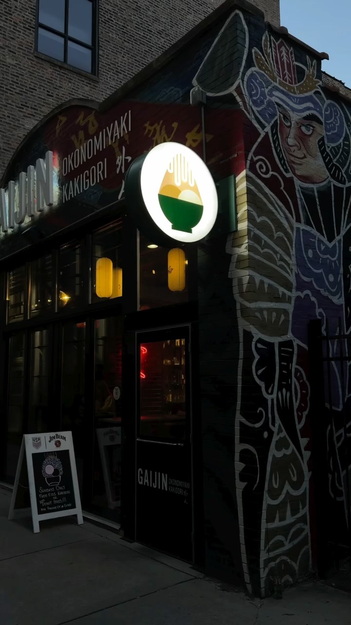Gaijin's corner entrance on Lake Street at dusk, with a glowing bowl sign and a painted samurai mural