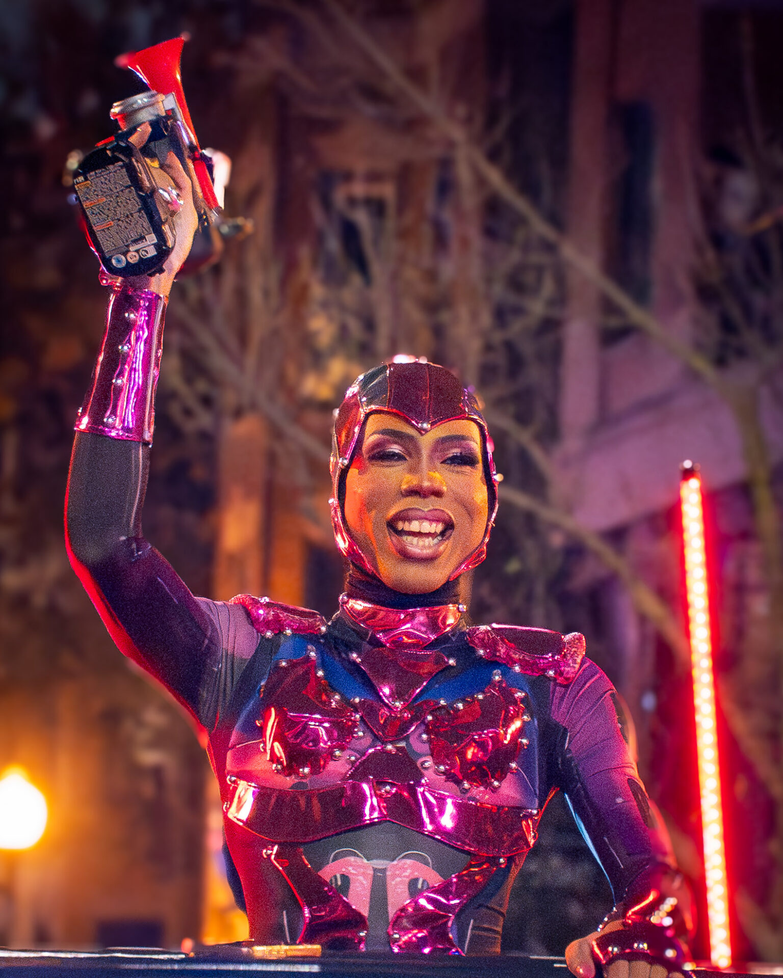 A costumed performer in glossy pink armor raises a horn on a float at the Haunted Halsted Halloween Parade in Chicago