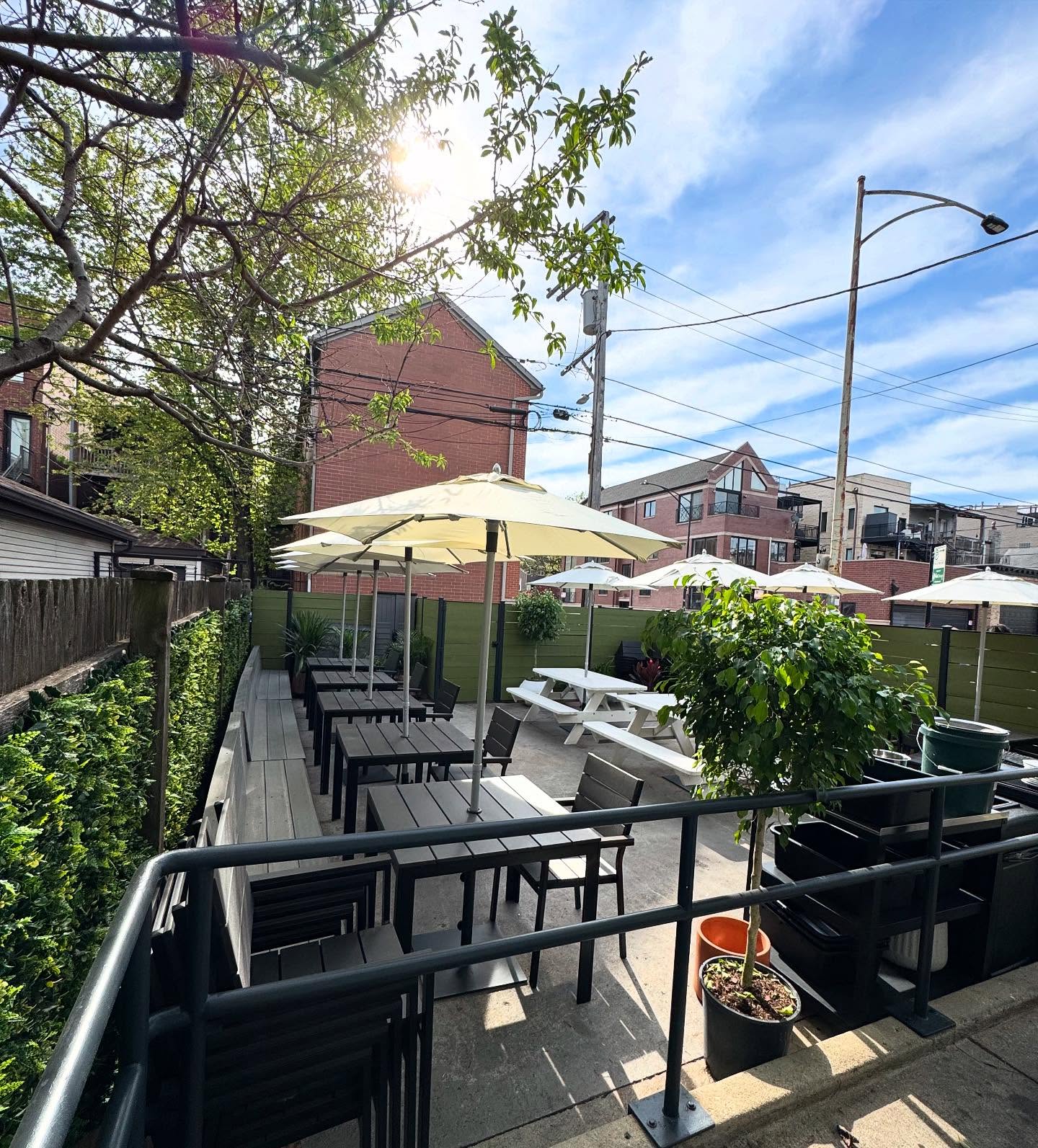 The Kasama patio on Winchester Avenue in Ukrainian Village with umbrellas, tables and a black railing