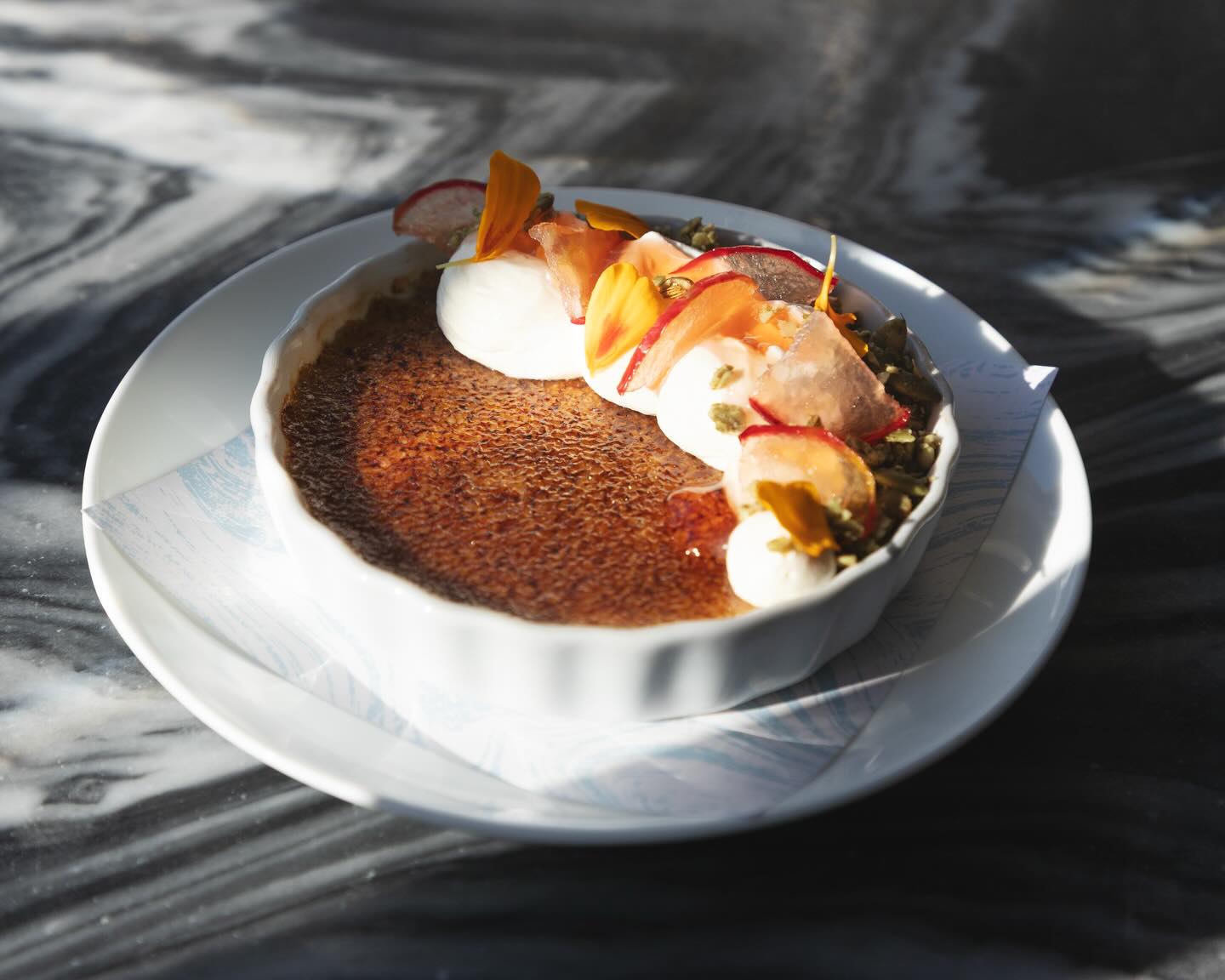 Toasted pepita creme brulee with apple jelly and celery root cream in a white ramekin at Lula Cafe