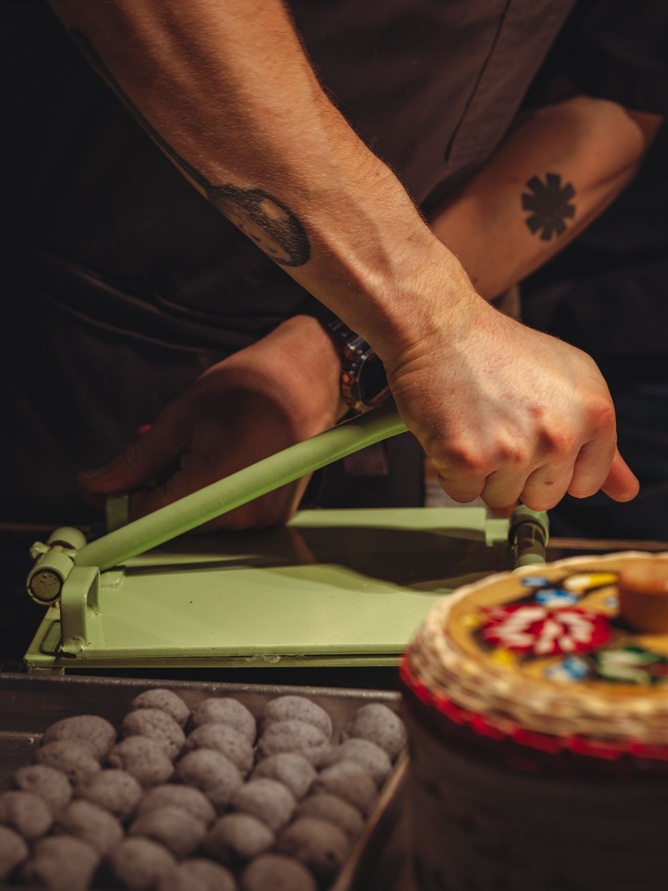 Molino Los Hermanos Chicago sibling kitchen pressing blue corn masa on a green tortilla press