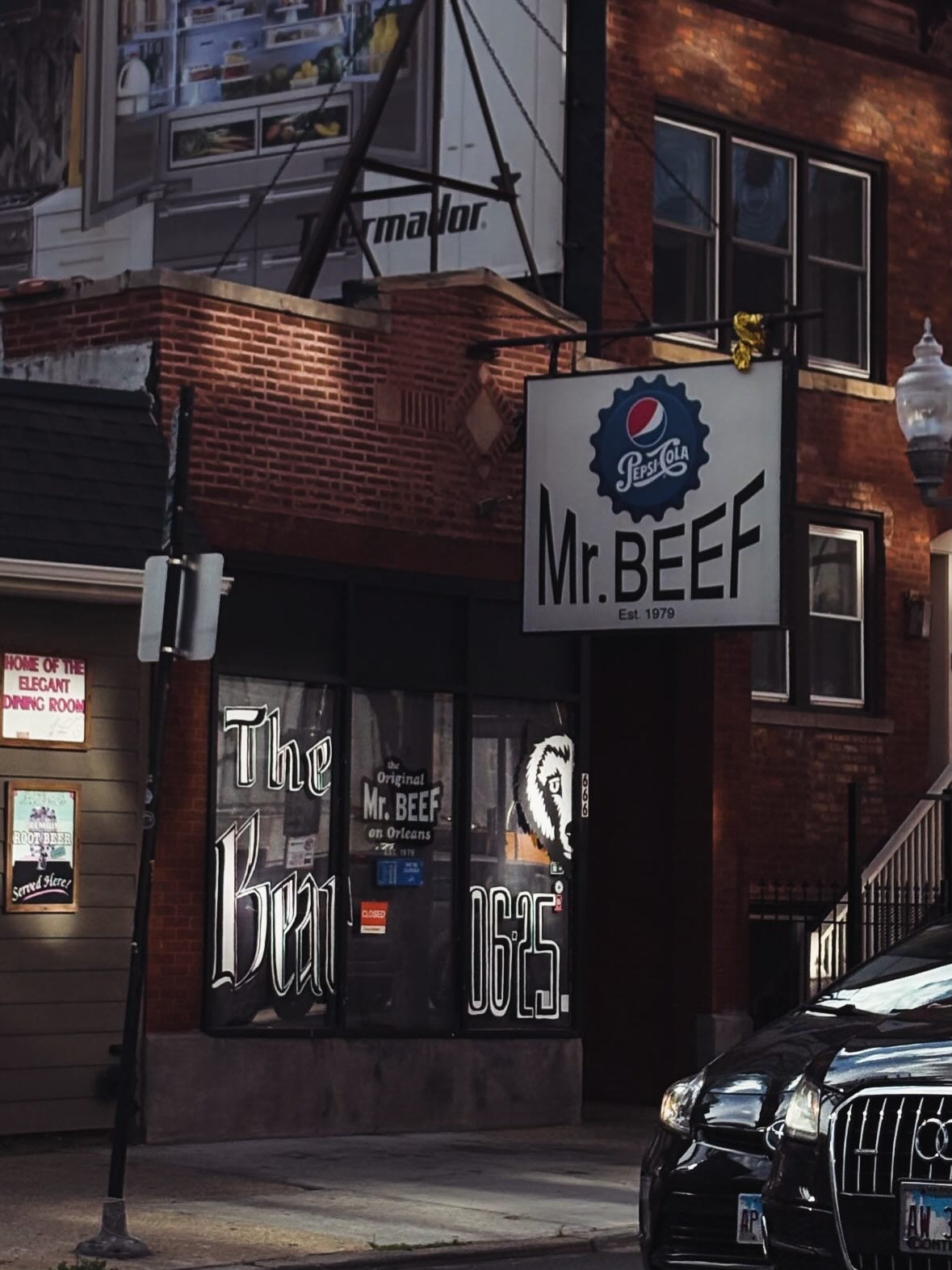 The Mr. Beef storefront on Orleans Street with its Pepsi sign and The Bear painted on the front windows
