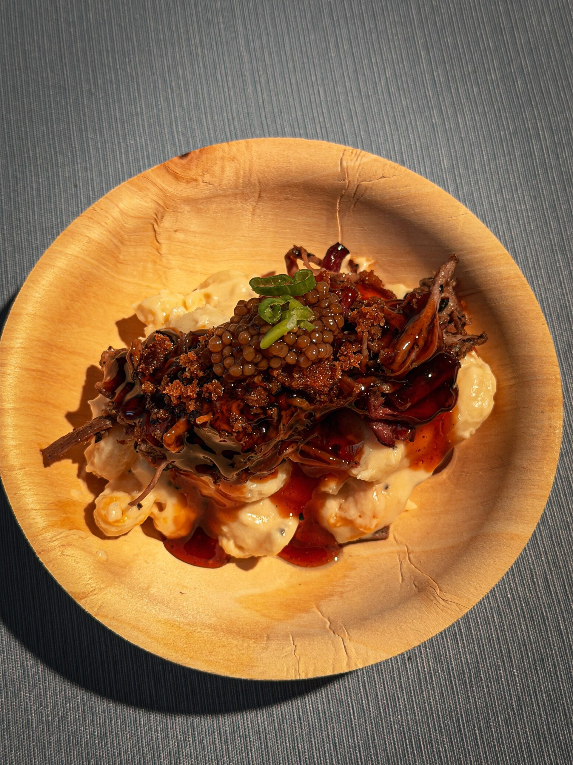 Sanders BBQ Prime–style elevated bowl — mac and cheese topped with smoked meat and mustard seeds