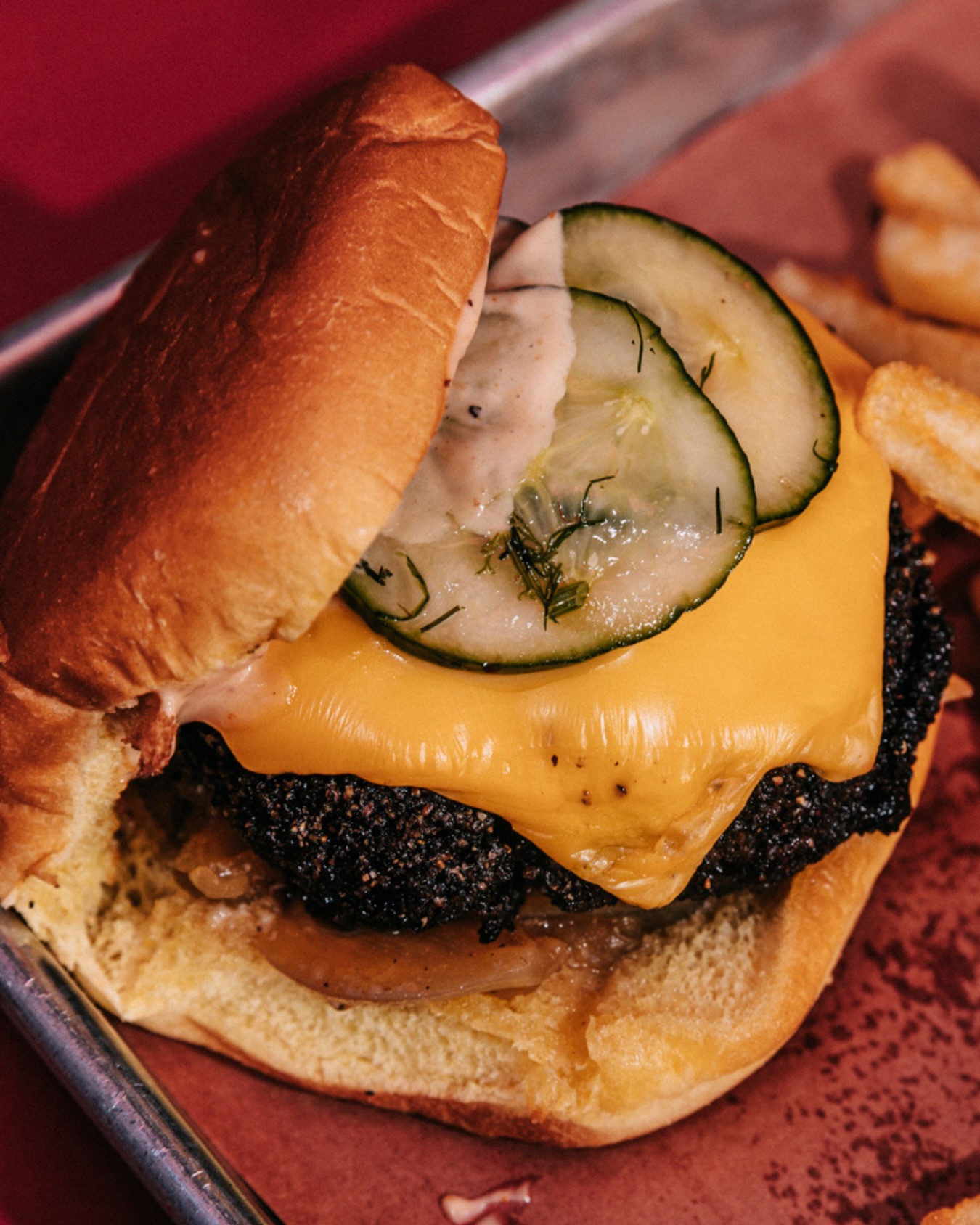 Sanders BBQ Prime cooking — smoke brisket burger with pickles and melted cheese