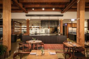 Smyth Chicago dining room with warm timber, low light and the open kitchen in the West Loop