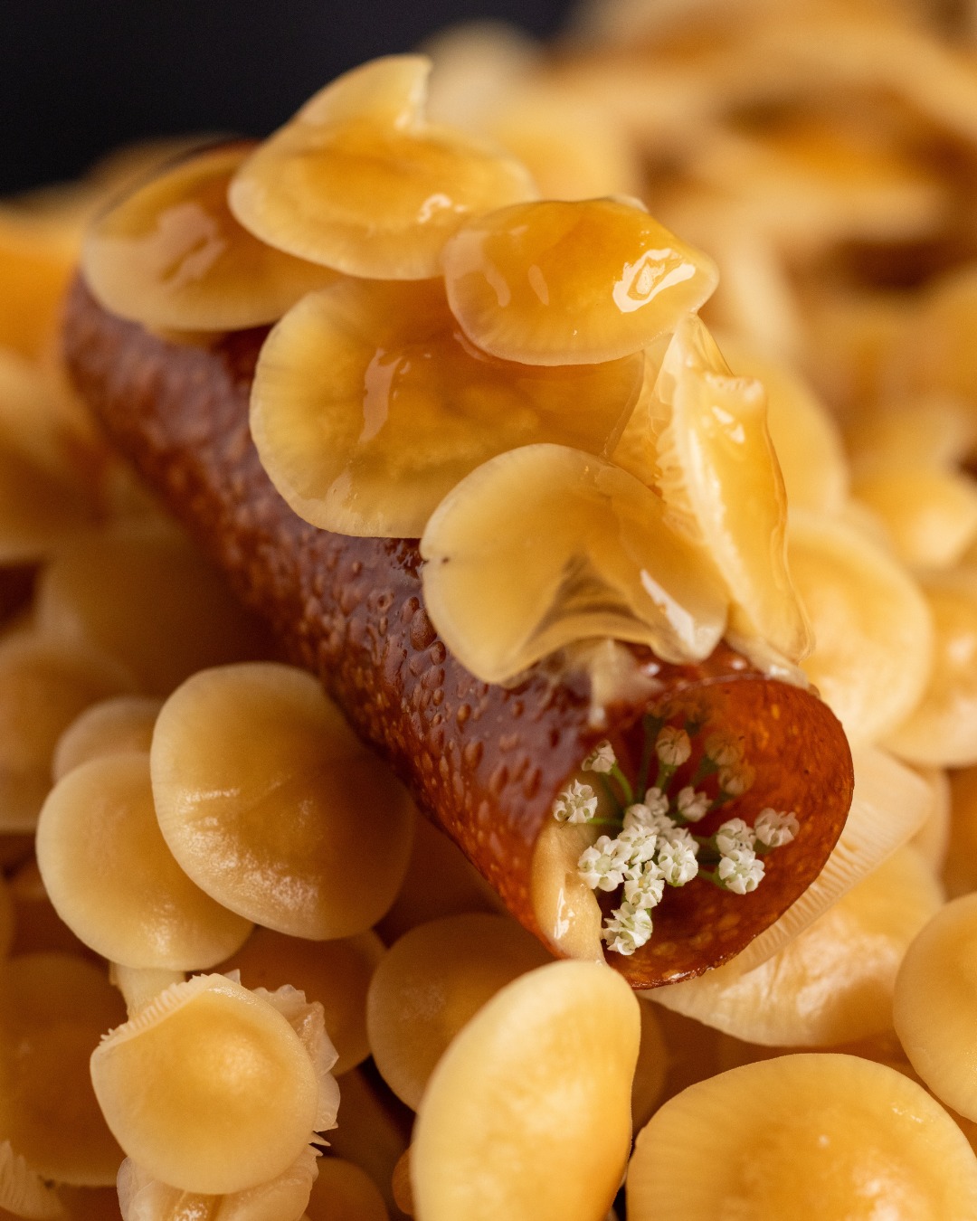 Smyth Chicago enoki cannoli opening bite with golden enoki mushrooms and blossoms