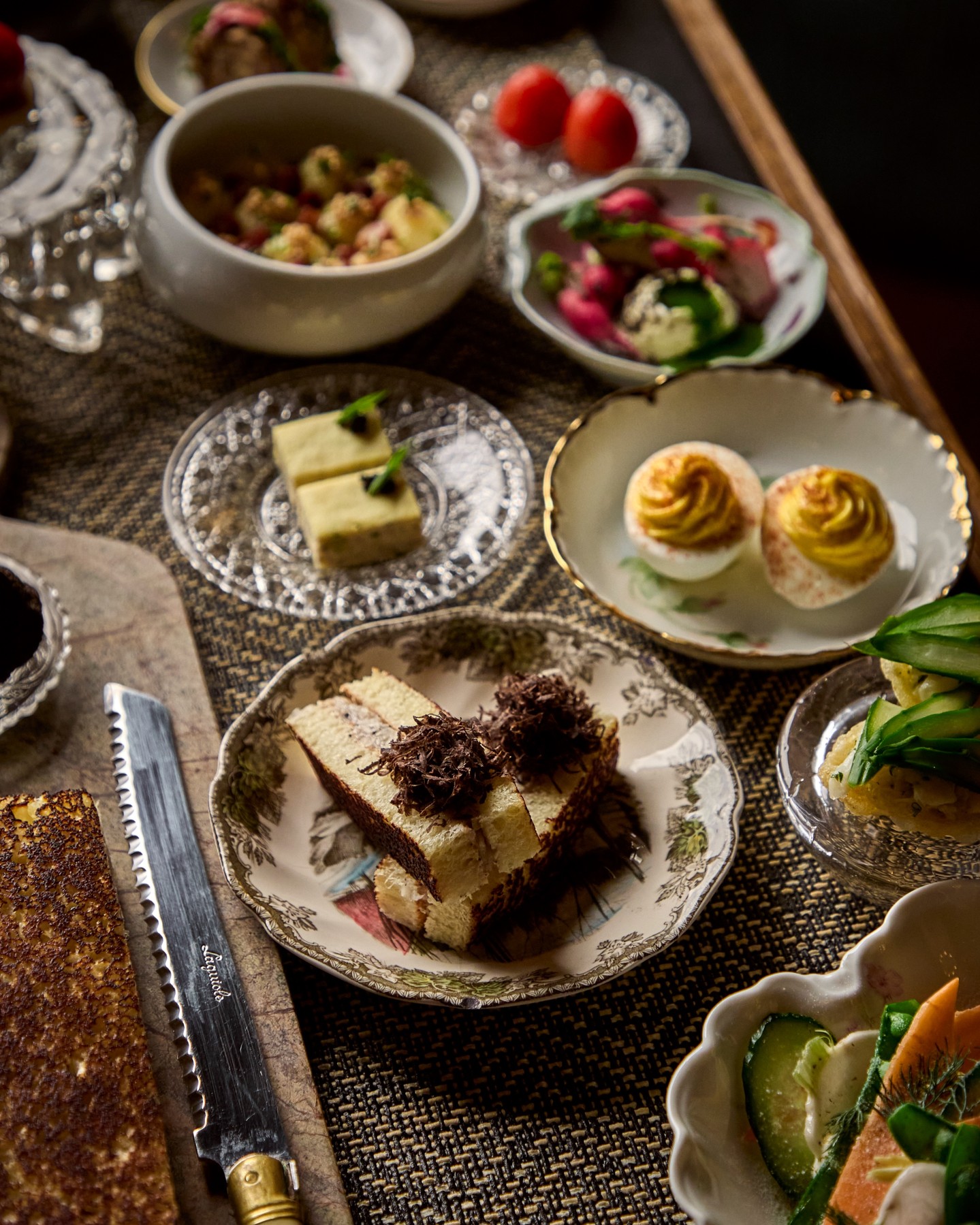 Overhead view of The Ives relish service with deviled eggs, strawberries, crudites and small plated bites on cut glass dishes
