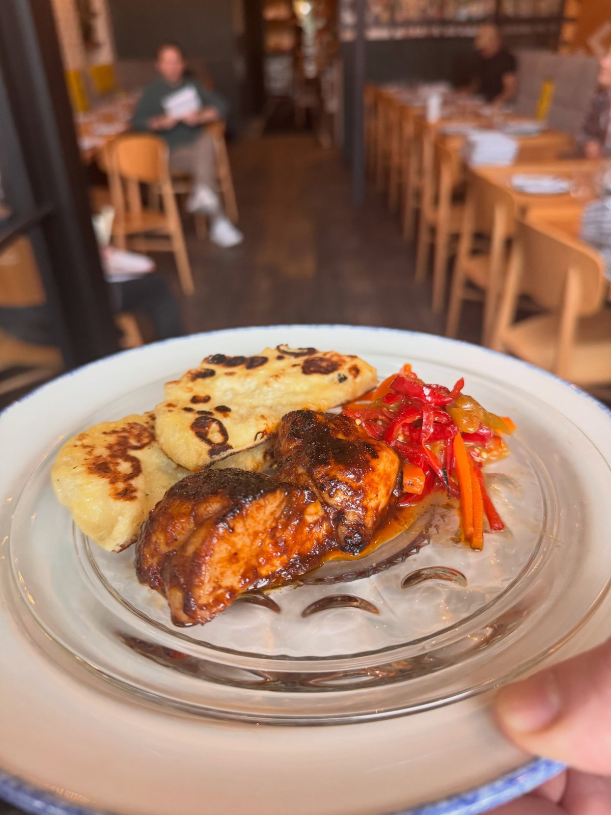 Charcoal grilled sweetbreads with Jimmy Nardello peppers and griddled flatbread on a plate in a dining room