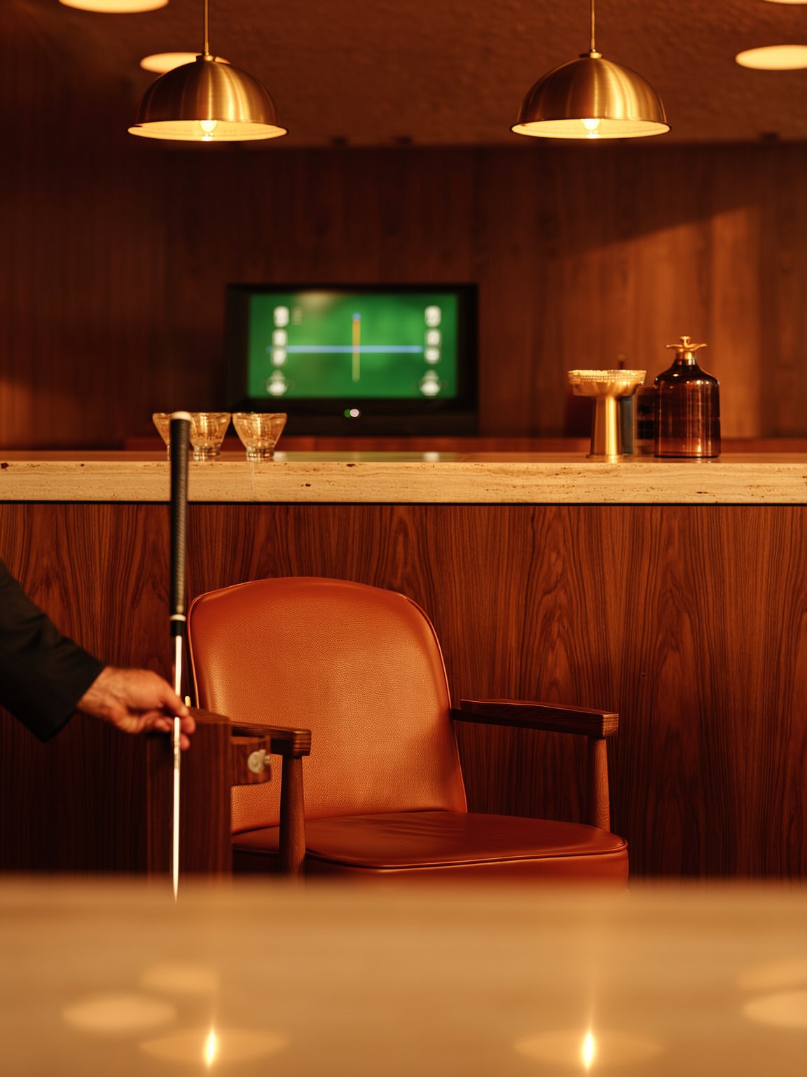 A hand resting a golf club against a leather lounge chair beside a wood-paneled bar at The Wayman Chicago
